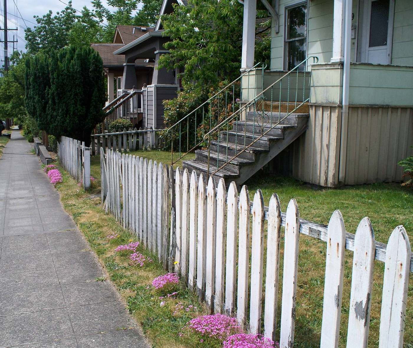 White wooden picket fence along a sidewalk